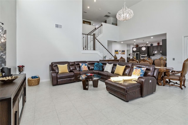 living room with a towering ceiling and a chandelier