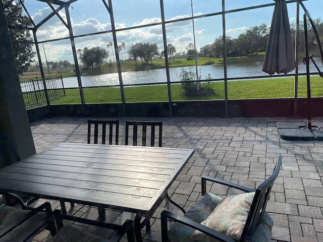 sunroom featuring a water view