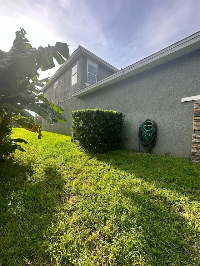 view of property exterior featuring a lawn