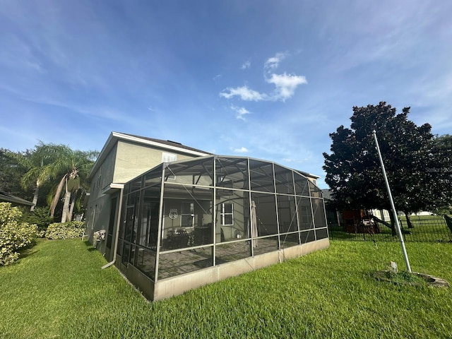 back of property with a lanai and a lawn