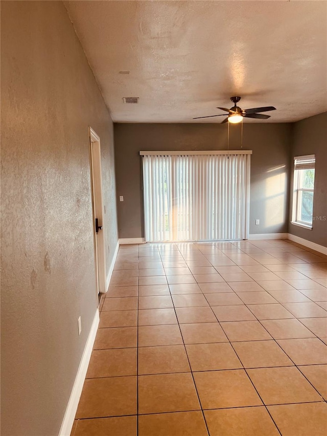 spare room featuring ceiling fan and light tile patterned floors