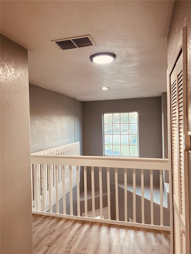 hallway featuring a textured ceiling and hardwood / wood-style floors