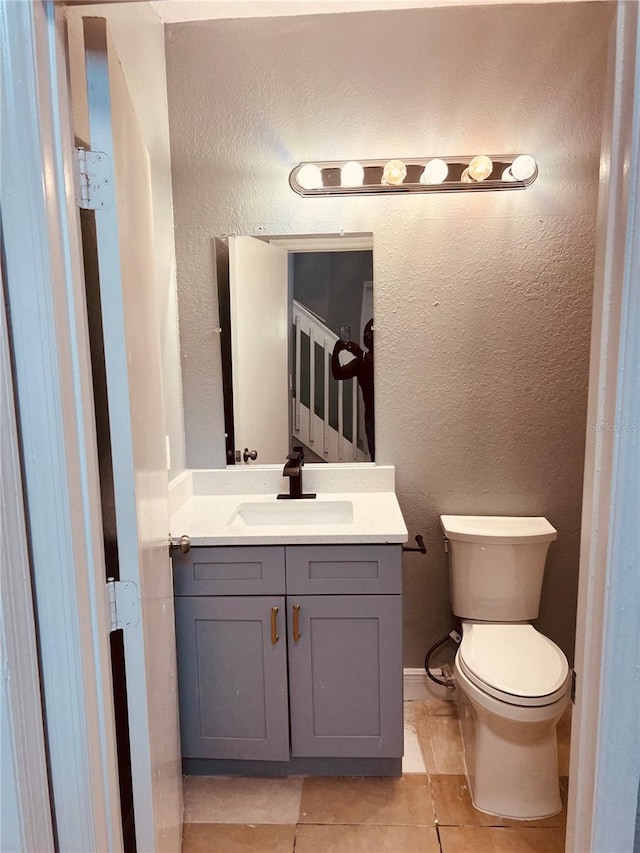 bathroom with vanity, toilet, and tile patterned floors