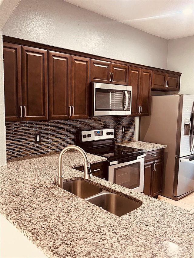 kitchen with dark brown cabinets, stainless steel appliances, and sink