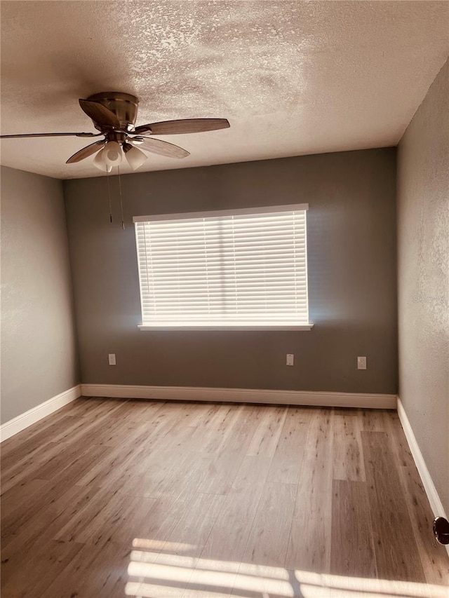 unfurnished room featuring ceiling fan, hardwood / wood-style flooring, and a textured ceiling