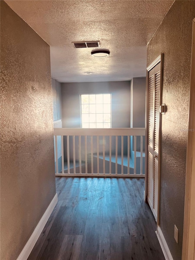 hallway featuring a textured ceiling and hardwood / wood-style floors