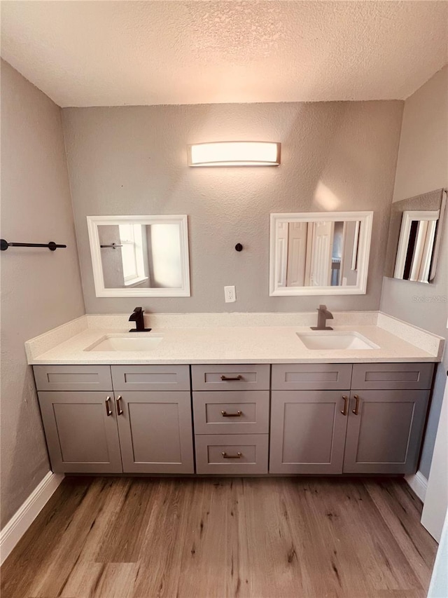 bathroom featuring a textured ceiling, wood-type flooring, and vanity