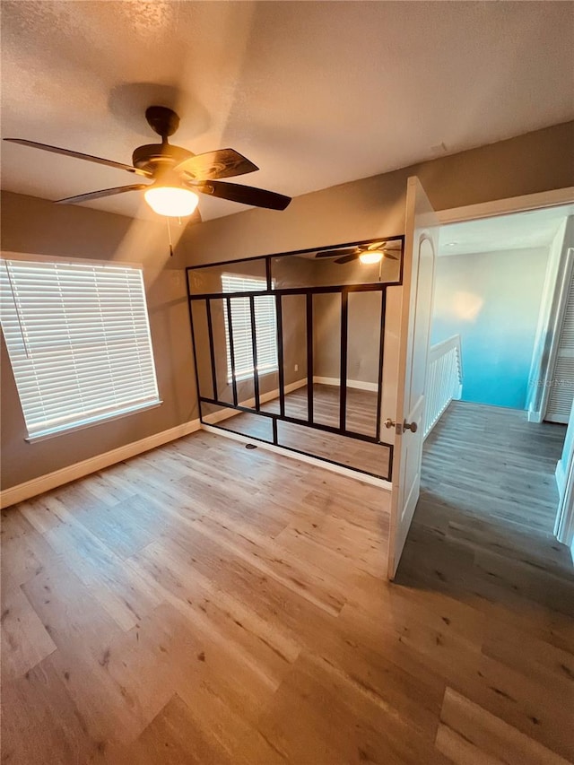 interior space with light hardwood / wood-style flooring, ceiling fan, and a textured ceiling