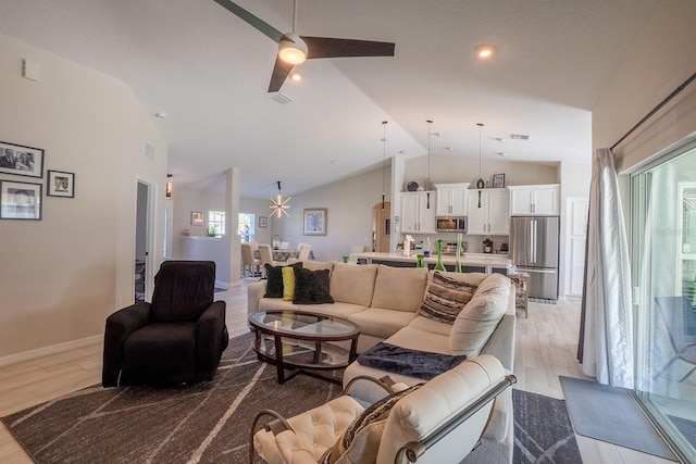 living room featuring light wood-type flooring, ceiling fan, and high vaulted ceiling