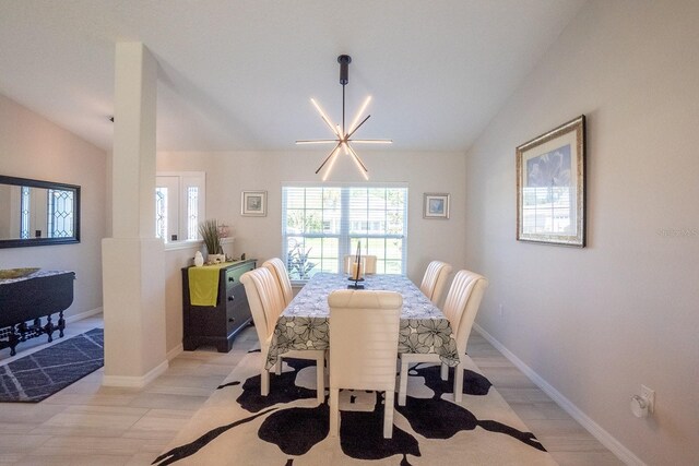 dining room featuring a notable chandelier, light hardwood / wood-style floors, and vaulted ceiling