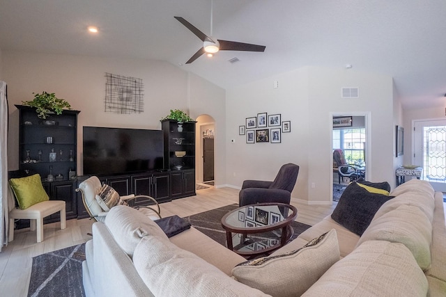 living room with light hardwood / wood-style floors, ceiling fan, and high vaulted ceiling