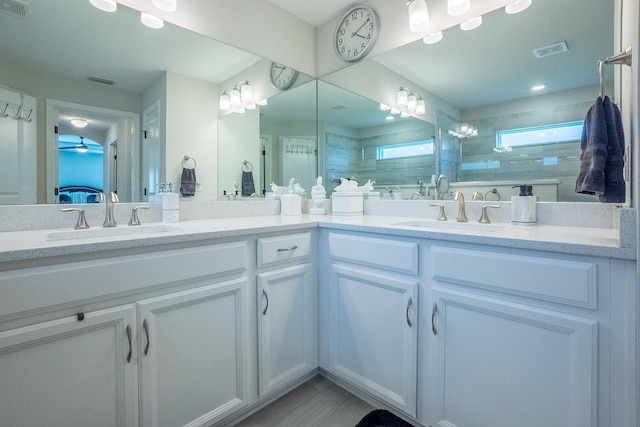 bathroom with ceiling fan, a shower with door, and vanity