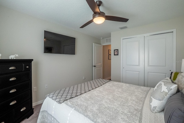 carpeted bedroom featuring ceiling fan, a textured ceiling, and a closet