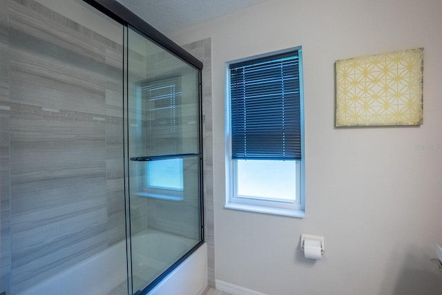 bathroom featuring bath / shower combo with glass door