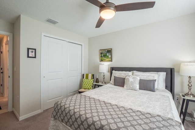 bedroom with a textured ceiling, carpet flooring, ceiling fan, and a closet