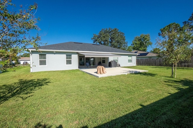 rear view of property with a lawn and a patio