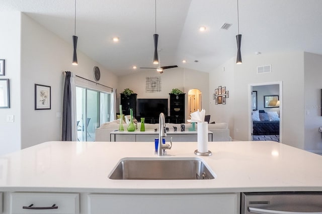 kitchen featuring lofted ceiling, a center island with sink, decorative light fixtures, and sink