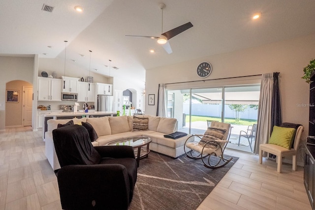 living room featuring light hardwood / wood-style floors, ceiling fan, and high vaulted ceiling