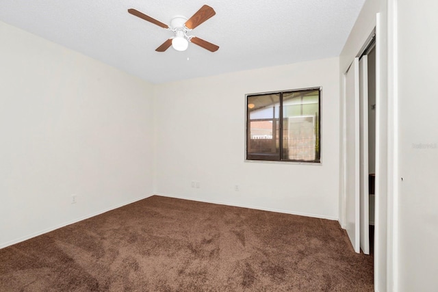 carpeted spare room with a textured ceiling and ceiling fan