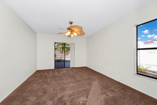 carpeted empty room with ceiling fan and a textured ceiling