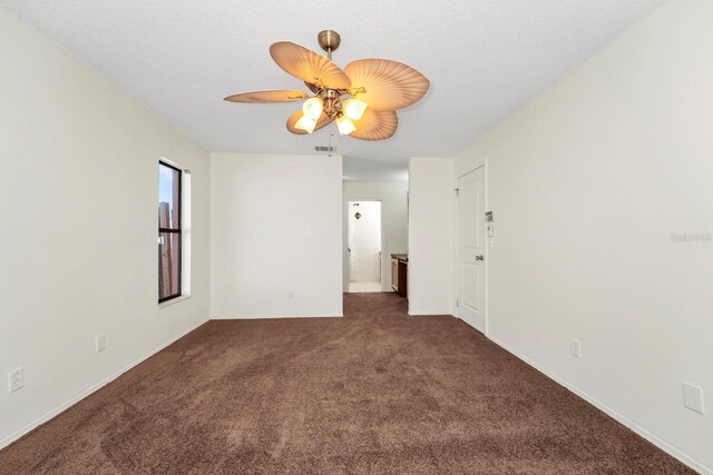 carpeted spare room featuring ceiling fan and a textured ceiling