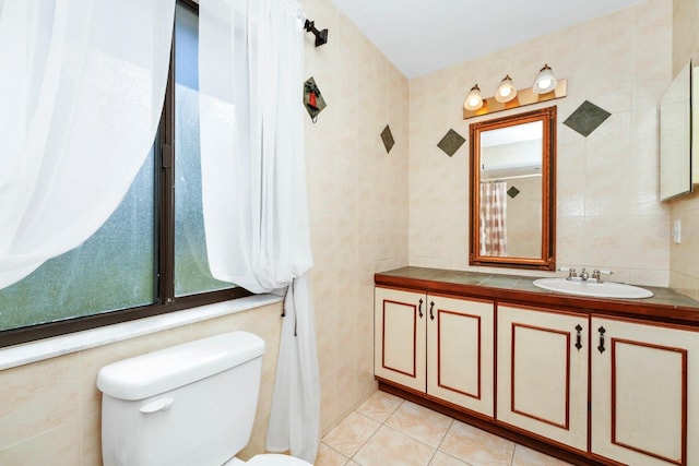 bathroom with tile walls, tile patterned floors, vanity, and toilet