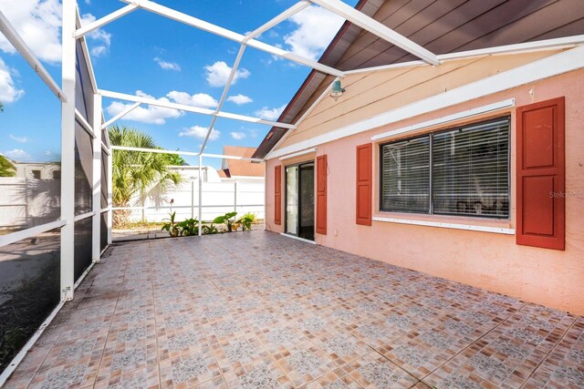 unfurnished sunroom featuring lofted ceiling with beams