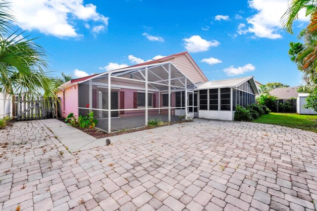 back of property featuring a sunroom, a lanai, and a patio area