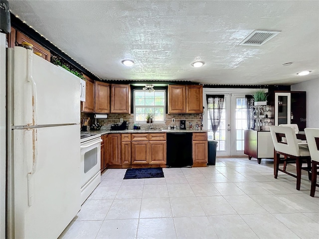 kitchen with a textured ceiling, decorative backsplash, white appliances, light tile patterned floors, and french doors