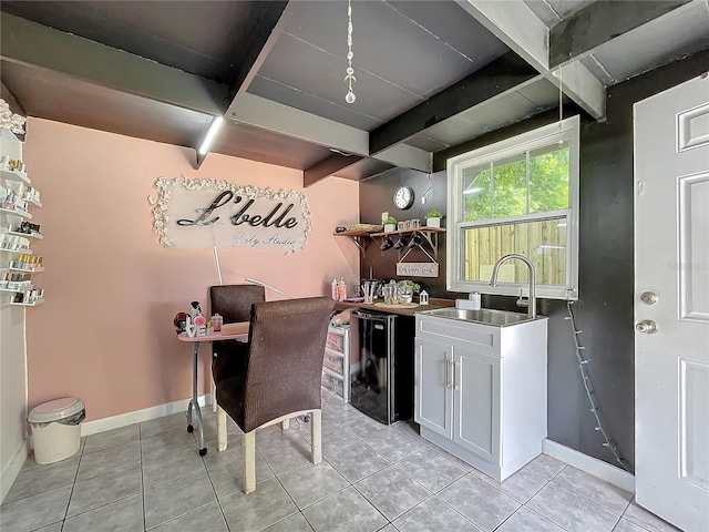 office with beam ceiling, light tile patterned flooring, and sink