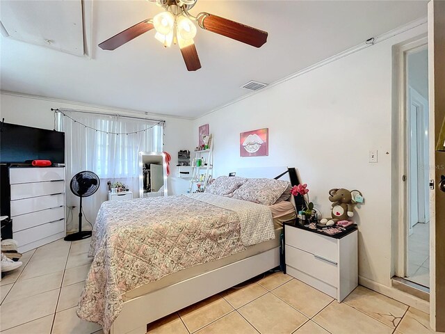 bedroom with ornamental molding, ceiling fan, and light tile patterned floors