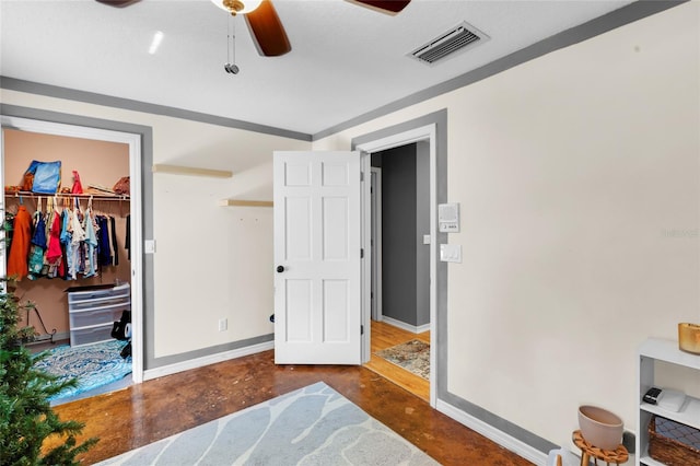 bedroom featuring ceiling fan, a closet, and a walk in closet