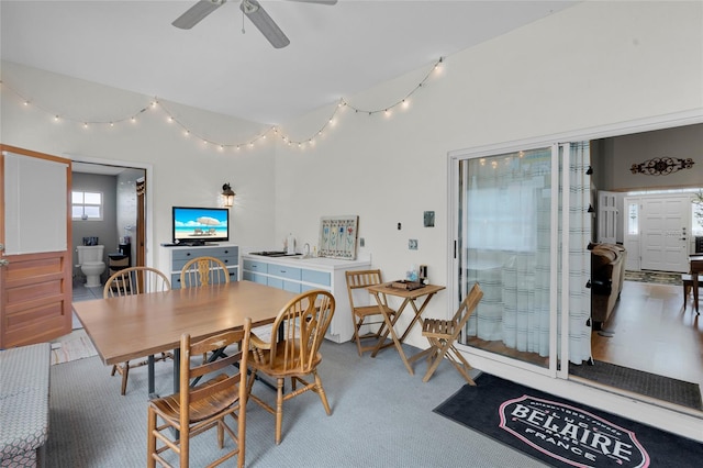 carpeted dining space featuring ceiling fan