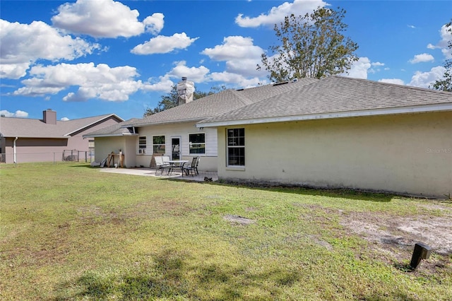 rear view of property with a patio and a lawn