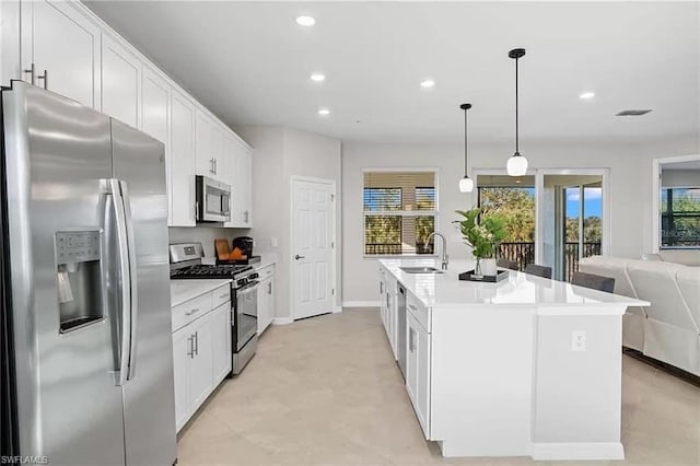 kitchen with sink, an island with sink, white cabinetry, hanging light fixtures, and stainless steel appliances