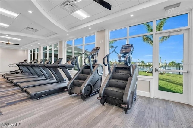 gym with ceiling fan and light hardwood / wood-style floors