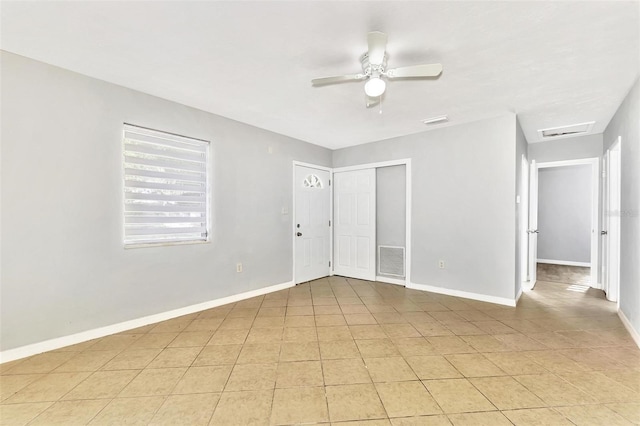 tiled empty room featuring ceiling fan