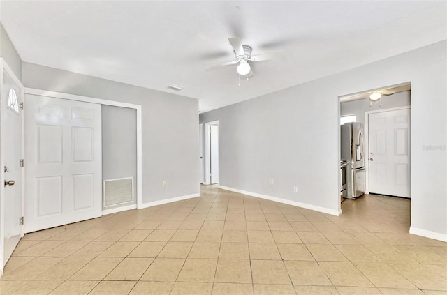 interior space featuring stainless steel fridge, light tile patterned floors, and ceiling fan