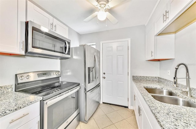 kitchen with appliances with stainless steel finishes, white cabinetry, light tile patterned floors, ceiling fan, and sink