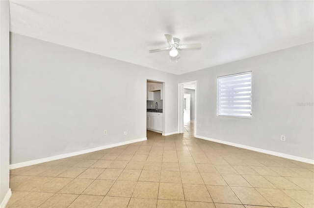 empty room with ceiling fan, sink, and light tile patterned floors