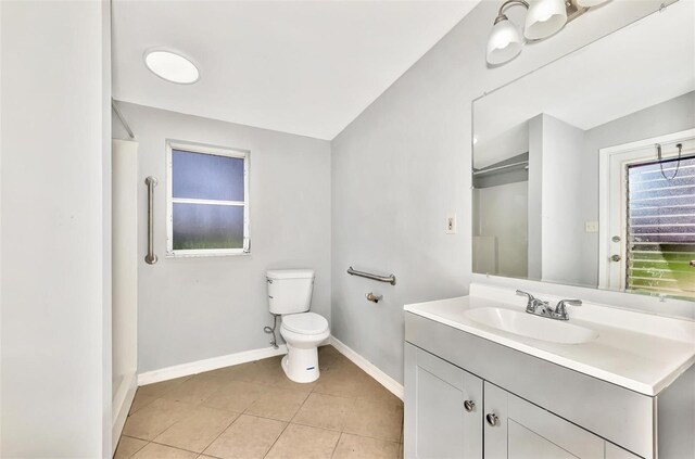 bathroom featuring lofted ceiling, tile patterned floors, vanity, and toilet