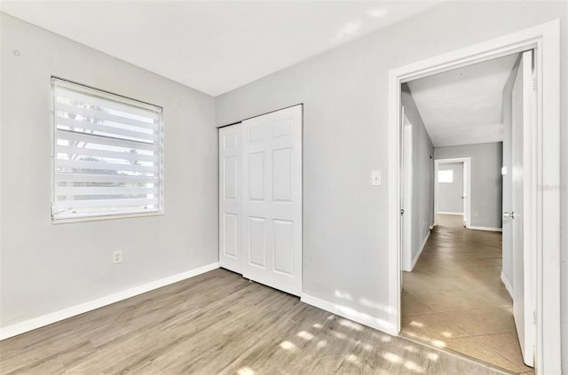 unfurnished bedroom with a closet and light hardwood / wood-style flooring