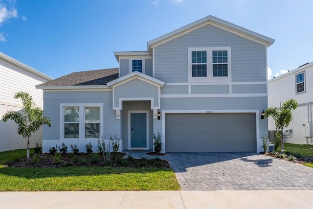 front facade with a garage and a front lawn