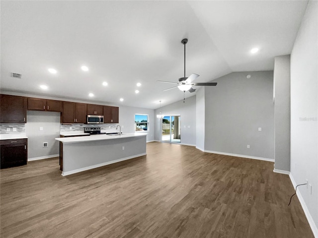 kitchen with ceiling fan, an island with sink, lofted ceiling, stainless steel appliances, and dark hardwood / wood-style flooring