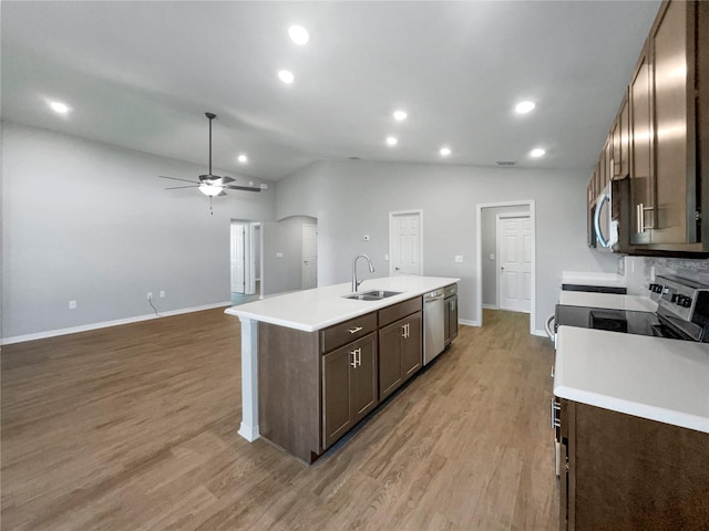 kitchen featuring ceiling fan, an island with sink, lofted ceiling, sink, and stainless steel appliances