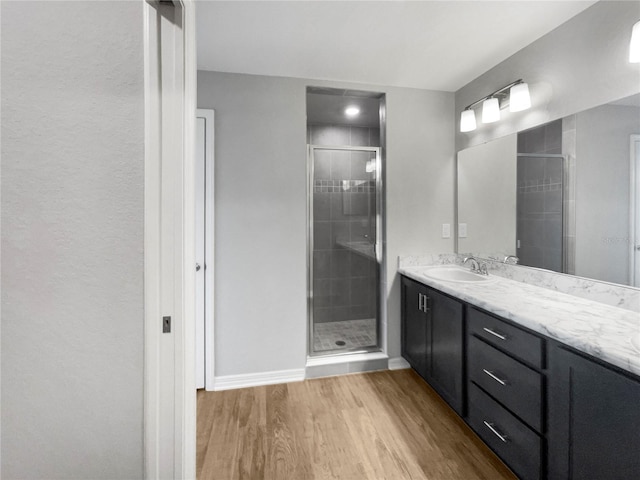 bathroom with hardwood / wood-style floors, an enclosed shower, and vanity