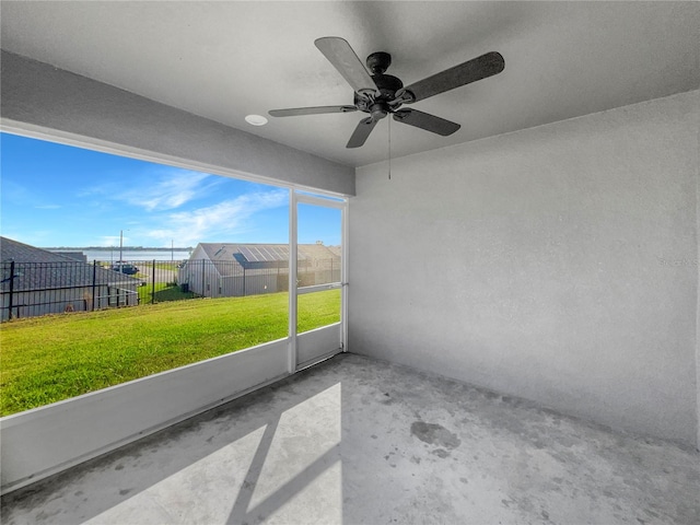 unfurnished sunroom with ceiling fan