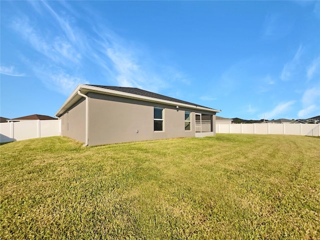 rear view of property featuring a yard