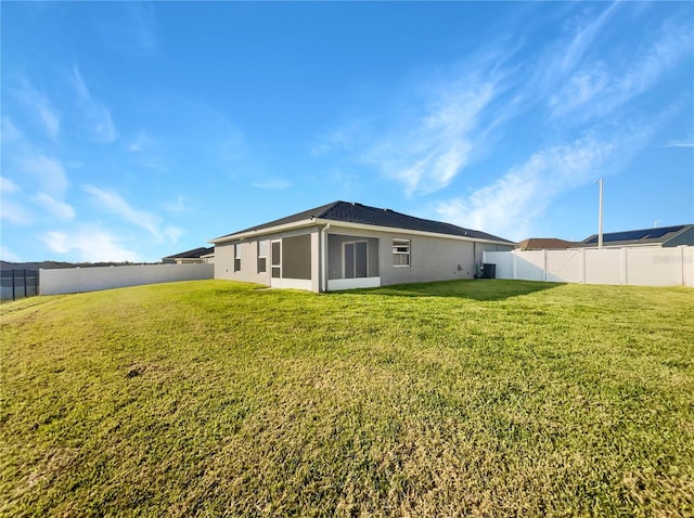 rear view of property featuring a lawn and a sunroom