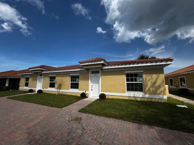 mediterranean / spanish-style house with a front yard